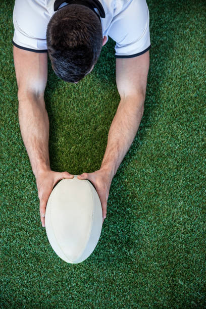 istock High angle view of man holding rugby ball with both hands 664209280