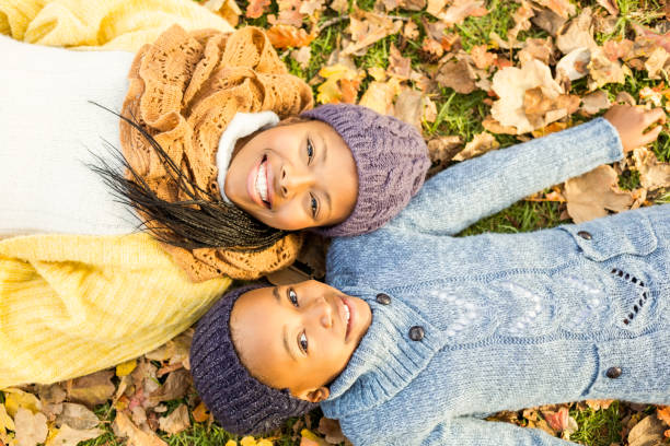 istock Young mother with her daughter lying in leaves 664210800