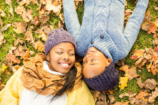 istock Young mother with her daughter lying in leaves 664210890