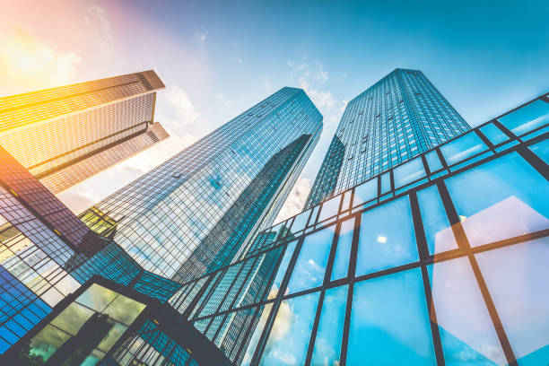 Modern skyscrapers in business district at sunset with lens flare effect Bottom view of modern skyscrapers in business district in beautiful evening light at sunset with monochrome retro vintage Instagram style filter and lens flare effect financial districts stock pictures, royalty-free photos & images