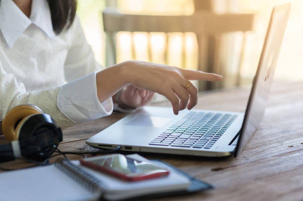 Dito donna che punta lo schermo del laptop. - foto stock