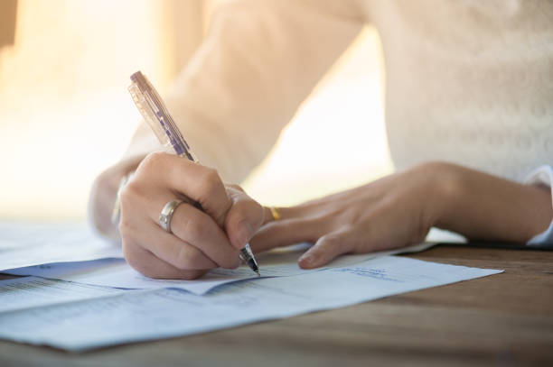 istock Woman hand writing on paper 664218920