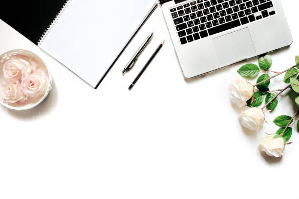 istock Modern minimalistic work place. White office desk table with laptop keyboard, pen, white roses, vintage tray. Top view with copy space, flat lay 664222074