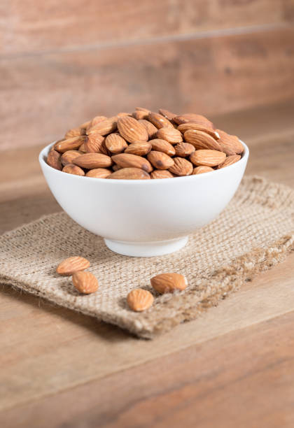istock Almond in white bowl on wooden table 664225138