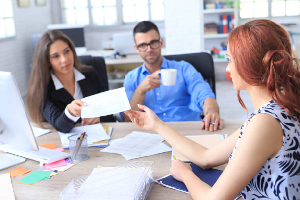 istock Young people filling documents in modern office 664233404