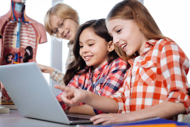 istock Lovely young ladies reading something on laptop 664234684