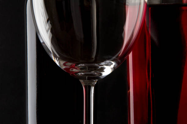Glass of red wine on a black reflective background. Selective fokus.