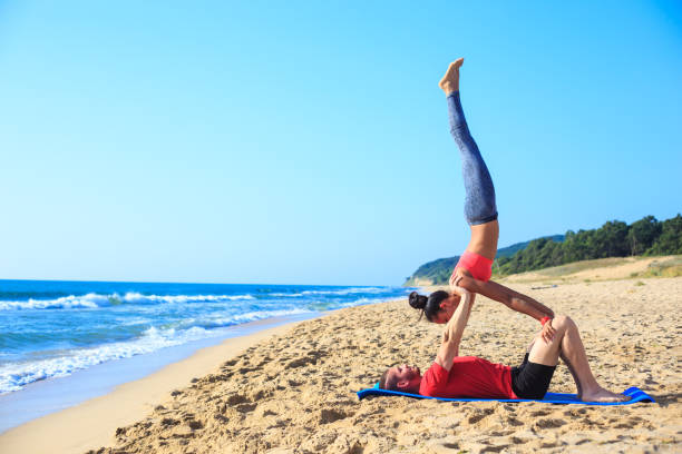para praktykujących pozycje jogi na plaży - teacher preparation two people teamwork zdjęcia i obrazy z banku zdjęć