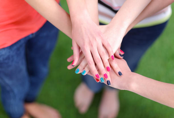 istock People joining their hands on green grass 664238016