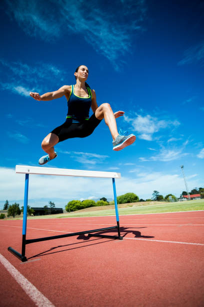 istock Female athlete jumping above the hurdle 664238104