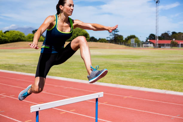 istock Female athlete jumping above the hurdle 664238408