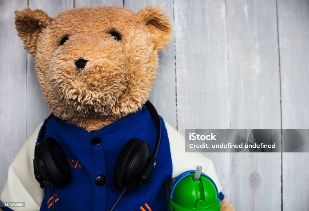 teddy bear with headphones on a teddy bear with headphones on wooden background Arts Culture and Entertainment Stock Photo