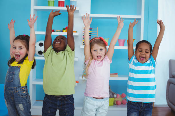 istock Happy kids with arms raised together 664242642