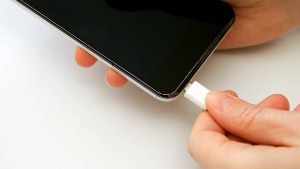 istock Female hand plugging charger cell phone smartphone 664245026