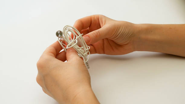 istock Woman untangles tangled earbuds or earphone knot 664245190