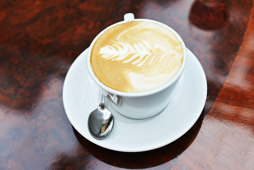 cup of cappuccino with brown and white foam on top