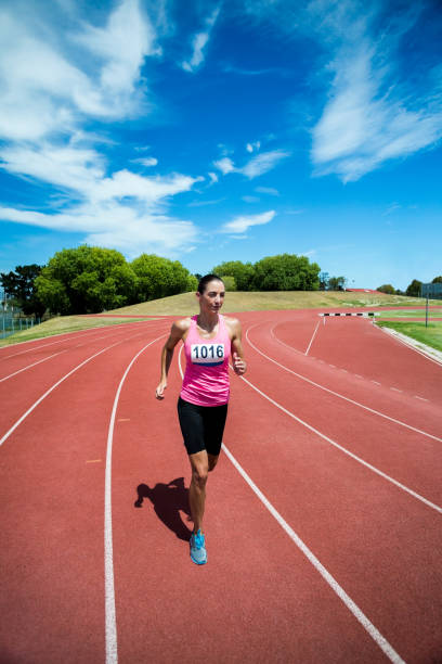 istock Female athlete running on the running track 664247538