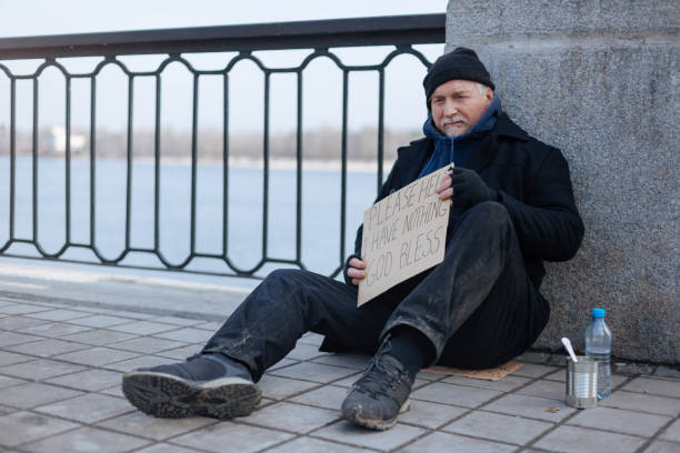 istock Homeless gray-haired man sitting on the tile 664255038