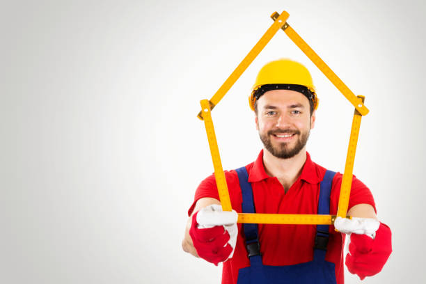 istock home improvement - handyman with house shaped ruler in hands on gray background with copy space 664263664