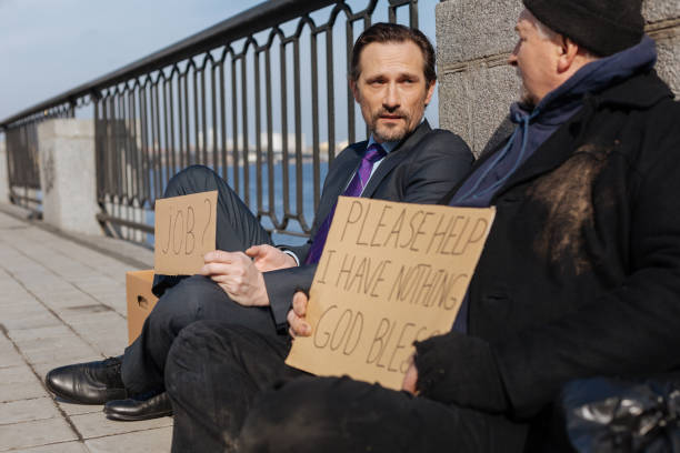 istock Two men sitting on the pavement from despair 664263850