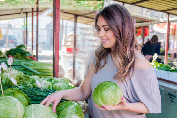 istock smiling good looking girl holding cabbage in her hands 664264014