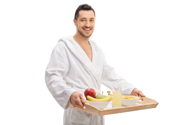 istock Cheerful guy in a bathrobe holding a breakfast tray 664266456