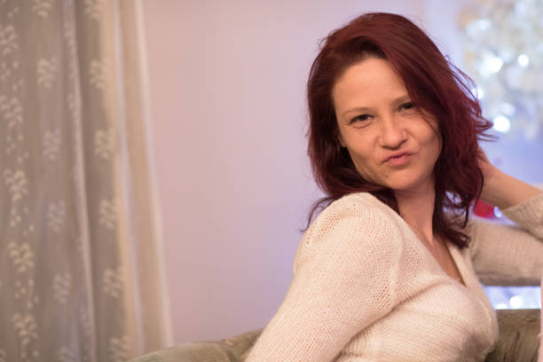 istock woman sitting on a couch at home 664277572
