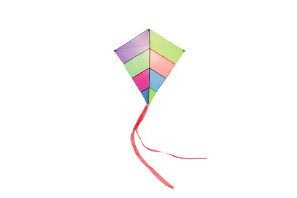 Photo of angle view of a colorful kite flying with waving red bow in a white background