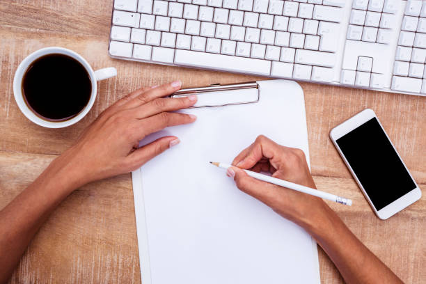 istock Businesswoman writing on clipboard on desk 664292378