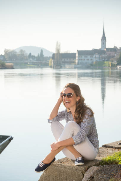 Young woman enjoys the sunny day in Stein am Rhein (CH) Young woman sits against the backdrop of the city of Stein am Rhein. sonnenbrille stock pictures, royalty-free photos & images