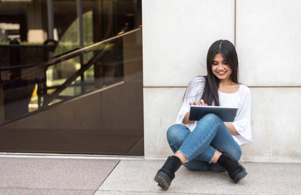 istock close up portrait student young woman with tablet smiling 664295288