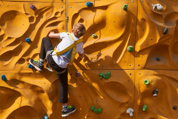 istock Child climbing a rock wall outdoor 664297410