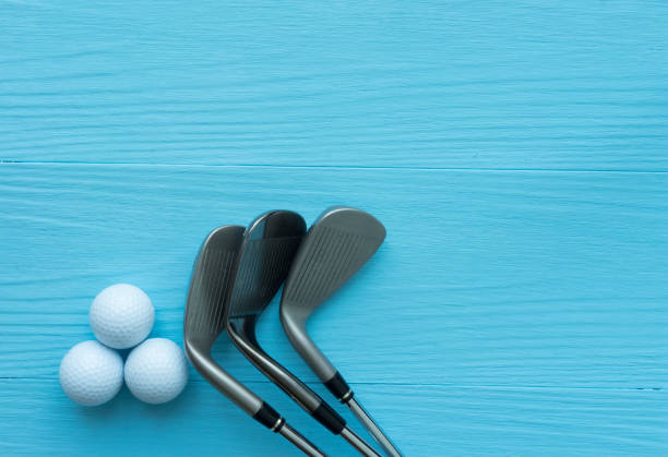 Golf clubs, golf balls on blue wooden table stock photo