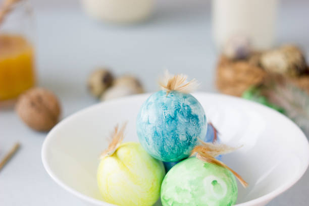 istock Green, yellow and blue easter eggs on ceramic bowl, bright and airy shot. 664304424