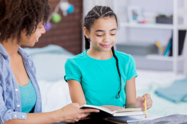 istock Tween girl works on homework in her room 664304488