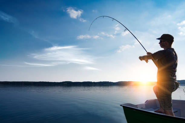 Fishing concepts. fishing rod lake fisherman men sport summer lure sunset water outdoor sunrise fish - stock image fishing rod photos stock pictures, royalty-free photos & images