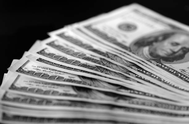 istock Hundred dollar bills on a dark background close up, black and white 664310182