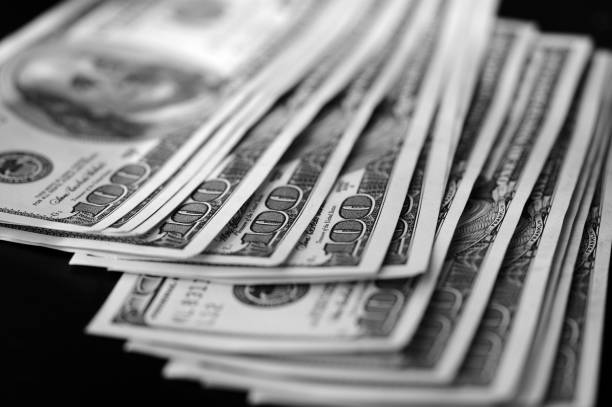 istock Hundred dollar bills on a dark background close up, black and white 664310186