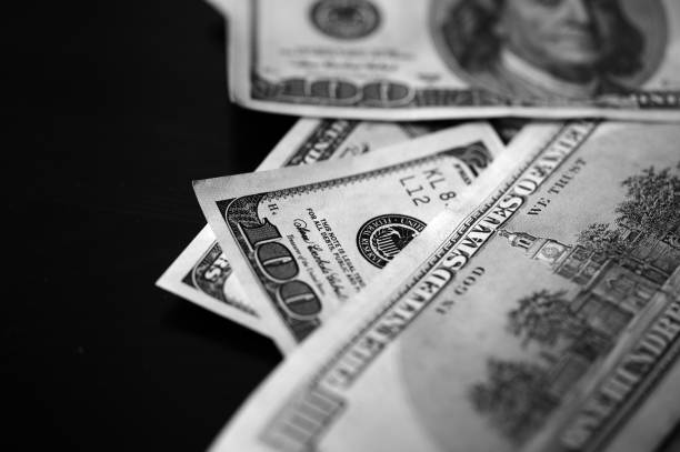 istock Hundred dollar bills on a dark background close up, black and white 664310206