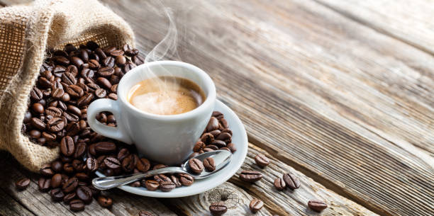 tazza caffè espresso con fagioli su tavola vintage - coffee foto e immagini stock