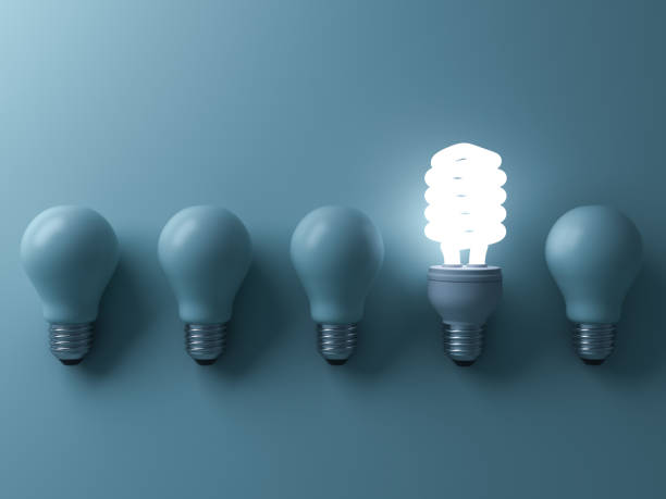 istock Energy saving light bulb , one glowing compact fluorescent lightbulb standing out from unlit incandescent bulbs on green background , individuality and different creative idea concepts . 3D render 664317174