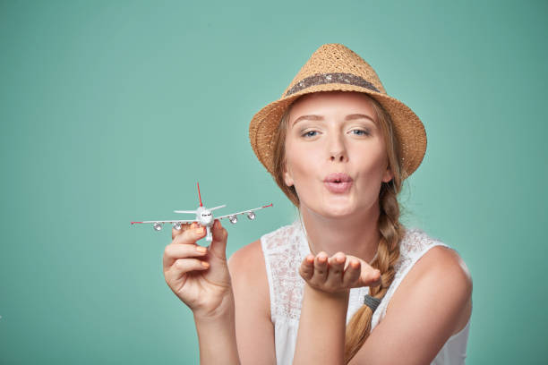 istock Woman in straw hat holding airplane model in hand 664333846