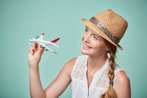 istock Woman in straw hat holding airplane model in hand 664336718