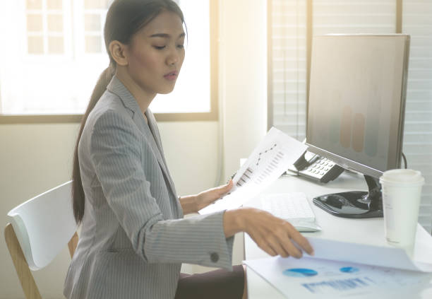 istock Business woman working in office with business graph on computer 664337134
