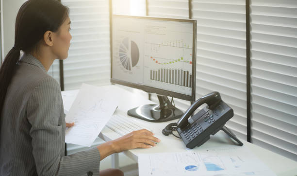 istock Business woman working in office with business graph on computer 664337160