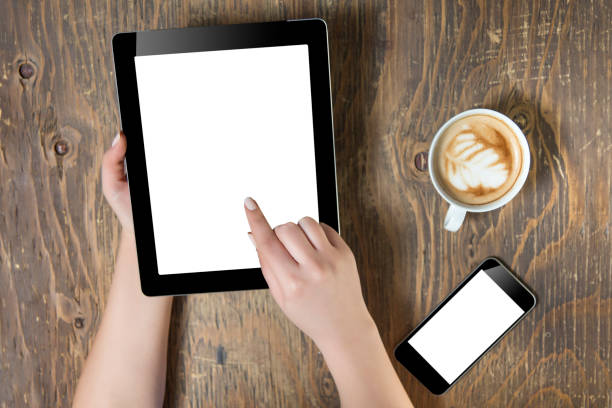 istock Woman hands holding tablet pc with empty screen on wooden background 664340814