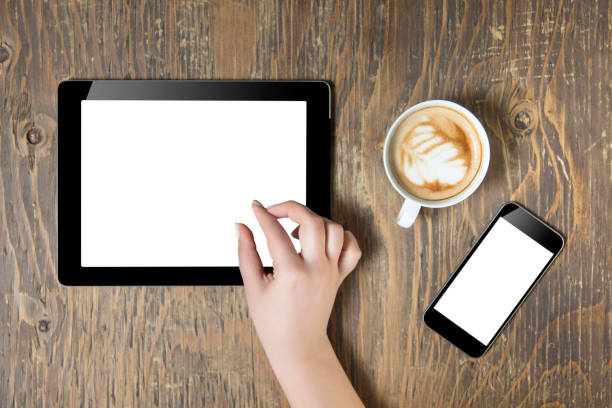istock Woman hands holding tablet pc with empty screen on wooden background 664340818