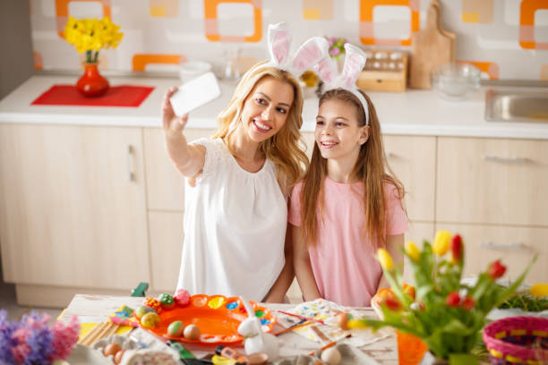 istock Woman with daughter make Easter selfie in kitchen 664347960