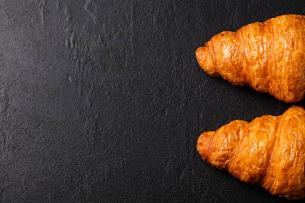 istock Fresh croissant on a black slate background. Top view. Copy space 664356928