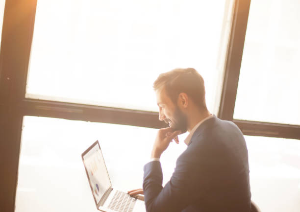istock Manager with a laptop, working with financial charts near a larg 664359794